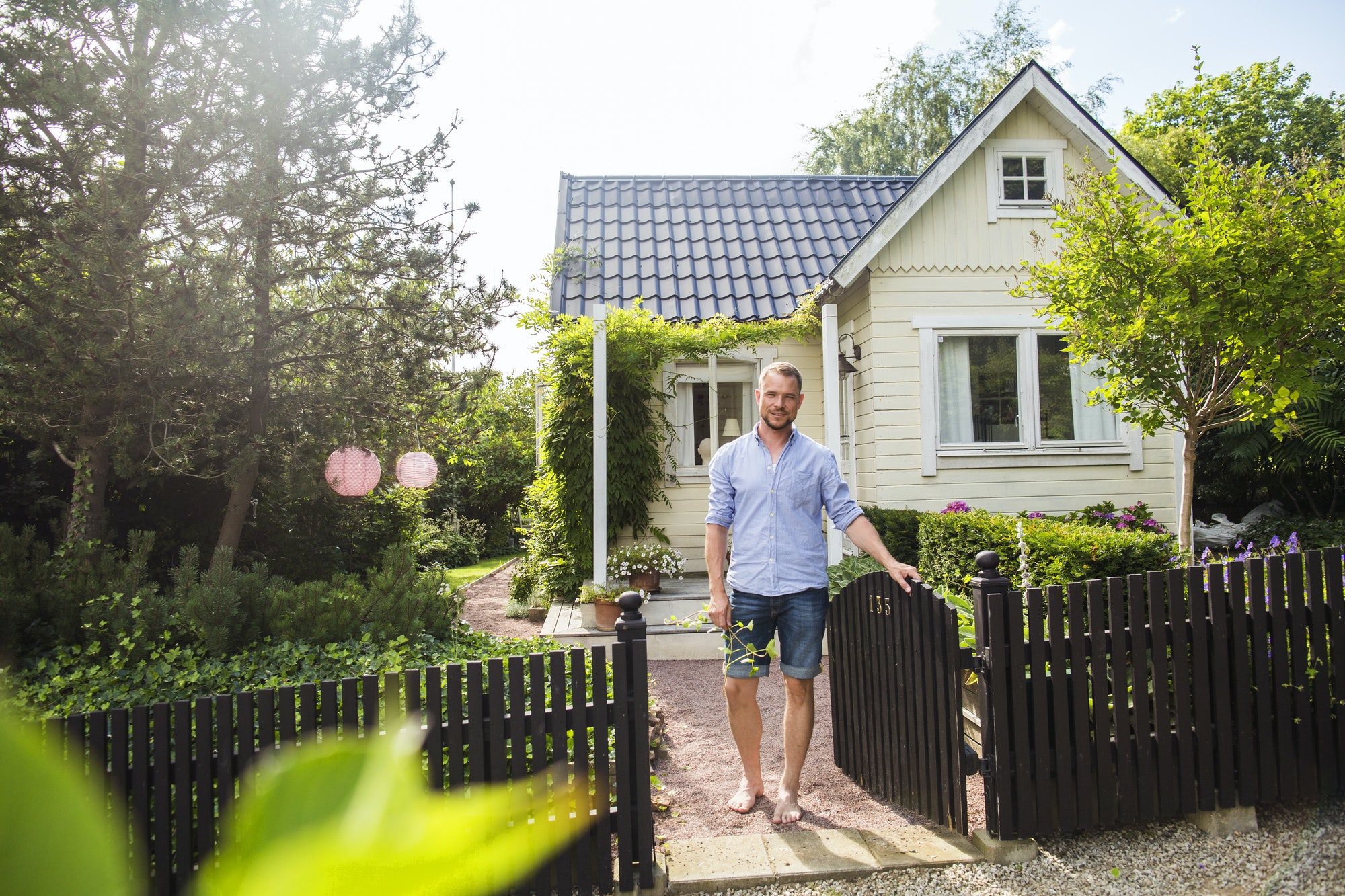 Portrait of man standing by fence